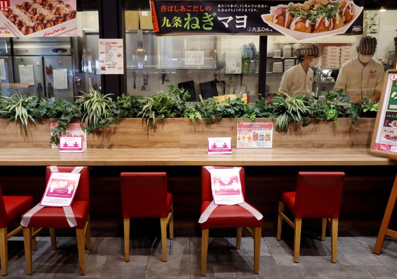 © Reuters. FILE PHOTO: Social distancing signs are place on a table and chairs at a restaurant in Japan's supermarket group Aeon's shopping mall as the mall reopens amid the coronavirus disease (COVID-19) outbreak in Chiba