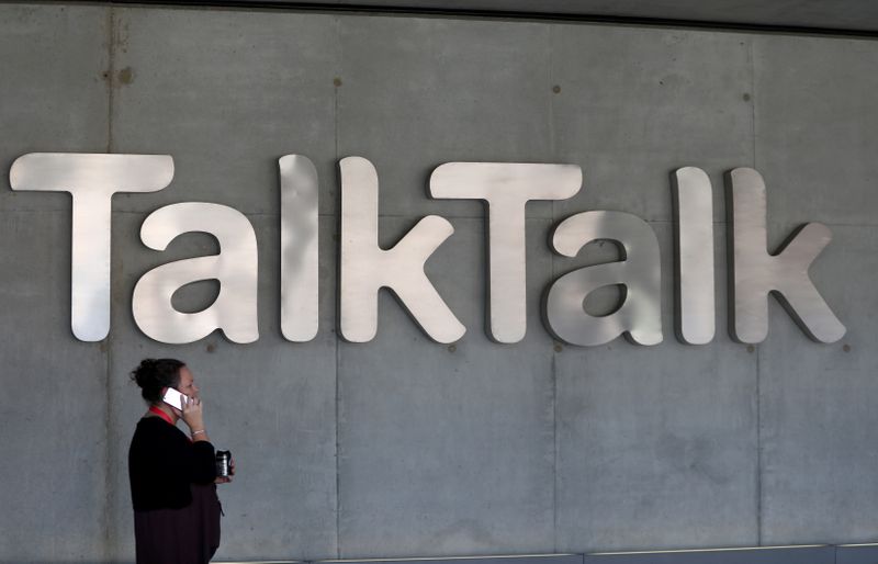 &copy; Reuters. A woman speaks on her phone as she passes a branded logo outside the Talktalk headquarters in London