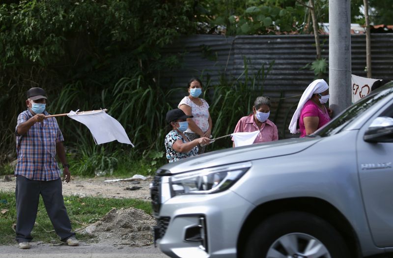 &copy; Reuters. Imagen de archivo. Ciudadanos de un barrio humilde de El Salvador ondean banderas blancas en señal de socorro para pedir comida.