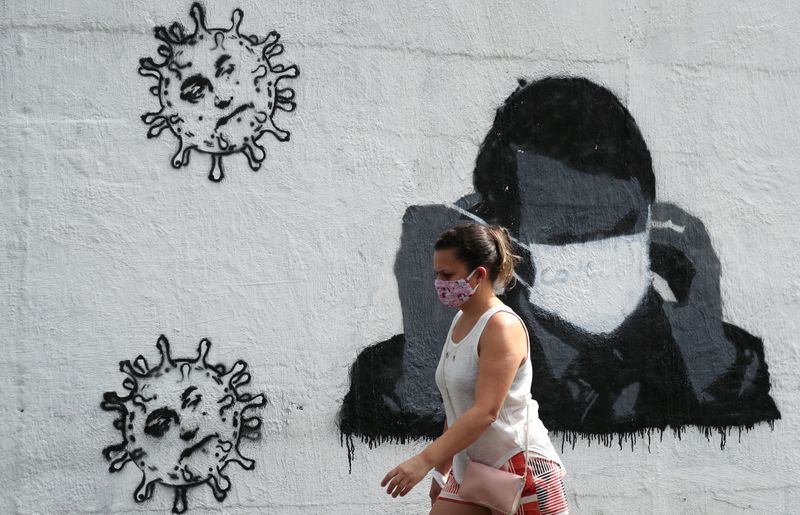 &copy; Reuters. Mulher passa por grafite em muro em rua do Rio de Janeiro