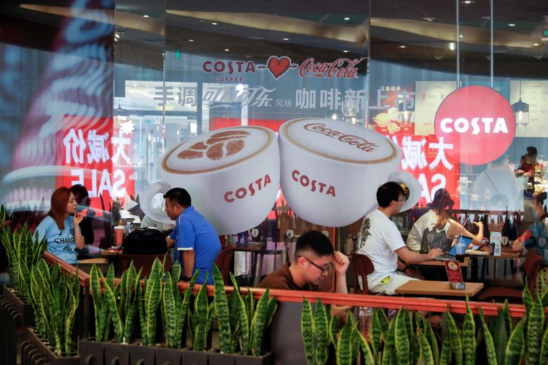 © Reuters. People sit on the terrace of an cafe of the British coffeehouse chain Costa Coffee in Beijing