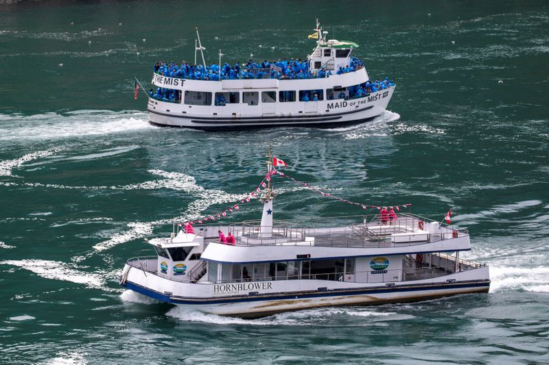 &copy; Reuters. American tourist boat glides past a Canadian vessel limited to just six passengers in Niagara Falls