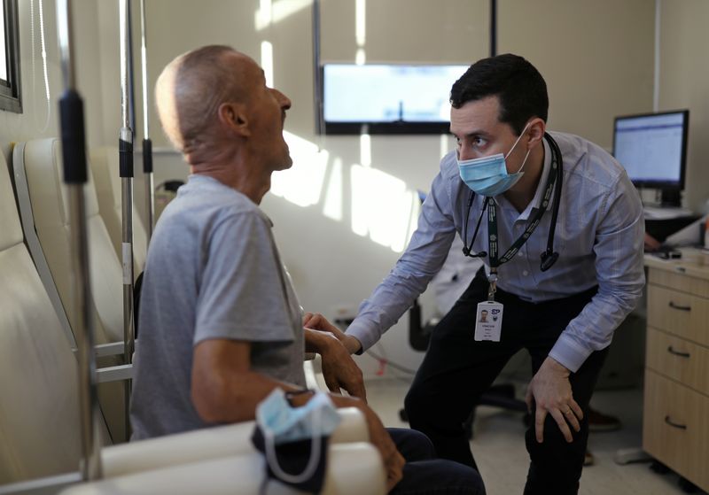 &copy; Reuters. FOTO DE ARCHIVO: Vinicius Molla, un hematólogo y voluntario del ensayo clínico de la vacuna de la Universidad de Oxford para el COVID-19, examina a un paciente en un consultorio en Sao Paulo, Brasil. 9 de julio de 2020.