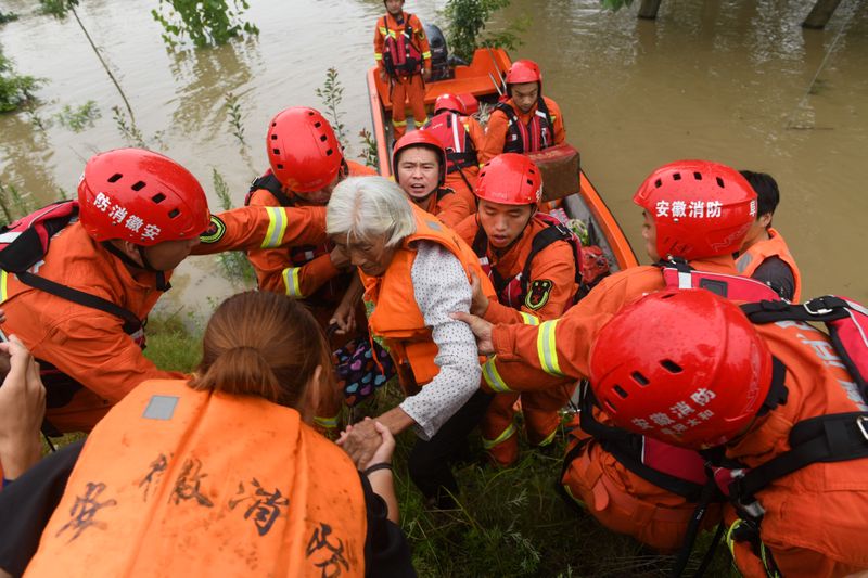 &copy; Reuters. Trabajadores de rescate evacúan a varias personas afectadas por las inundaciones en Funán