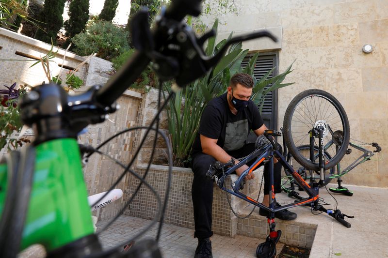 © Reuters. Palestinian cyclist Samer Kurdi inspects his damaged bicycle in Ramallah in the Israeli-occupied West Bank