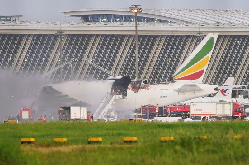 &copy; Reuters. Firefighters work at the site where an Ethiopian Airlines cargo plane caught fire, at Shanghai Pudong International Airport