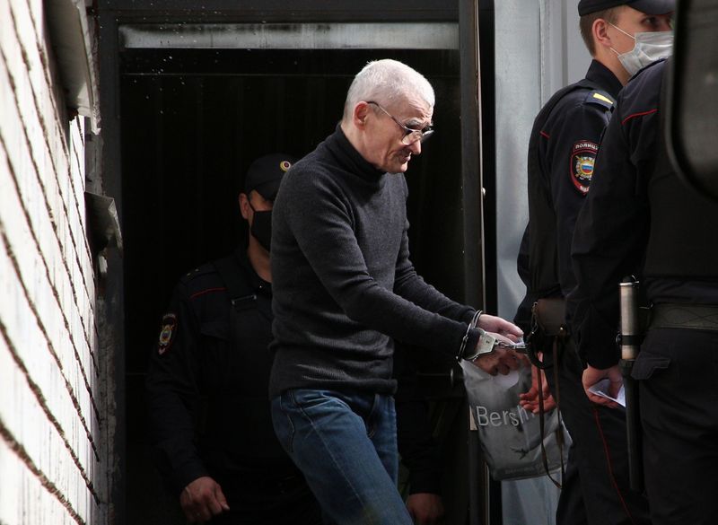 © Reuters. Russian historian Yuri Dmitriev is escorted by police officers after a court hearing in Petrozavodsk