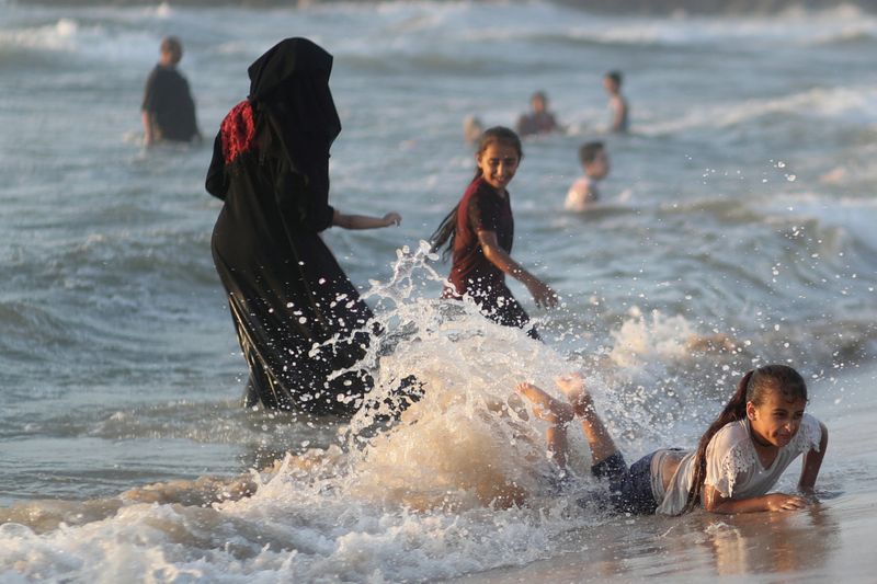 © Reuters. Palestinians enjoy the beach after COVID-19 restrictions were eased, in Gaza City