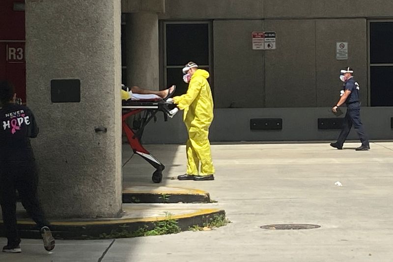 &copy; Reuters. A patient is brought to Jackson Health Center by paramedics wearing protective clothing in Miami