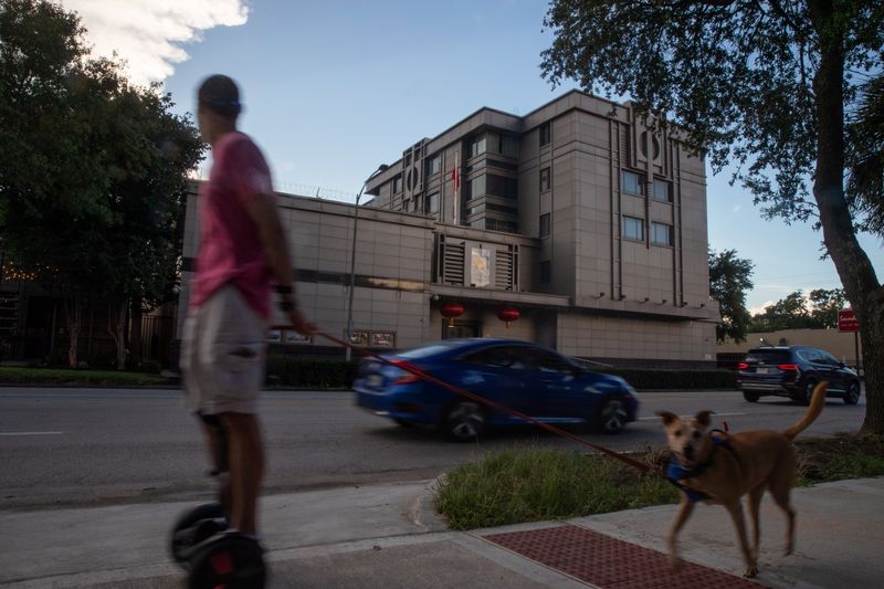 &copy; Reuters. Un hombre pasea a su perro por el Consulado General de China en Houston, Texas, Estados Unidos.