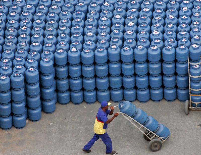© Reuters. Trabalhador transporta botijões de gás em São Paulo