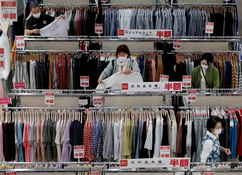 &copy; Reuters. FILE PHOTO: Shoppers wearing protective masks choose clothes at Japan&apos;s supermarket group Aeon&apos;s shopping mall as the mall reopens amid the coronavirus disease (COVID-19) outbreak in Chiba