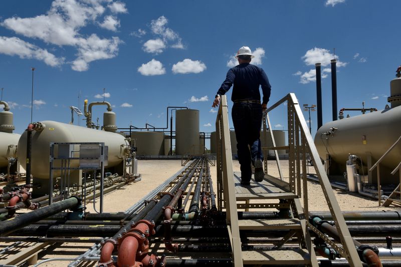 &copy; Reuters. FILE PHOTO: Lease Operator Jeremy Jay walks through an oil production facility owned by Parsley Energy in the Permian Basin near Midland