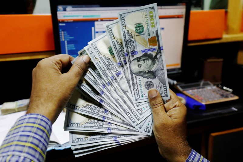 © Reuters. Банкноты долларов США в пункте обмена валют в Карачи