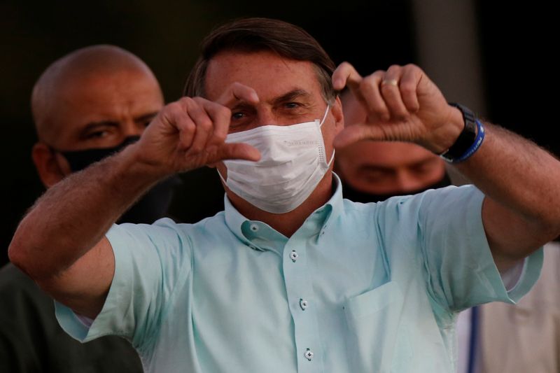 &copy; Reuters. Presidente Jair Bolsonaro gesticula para apoiadores no Palácio da Alvorada, em Brasília