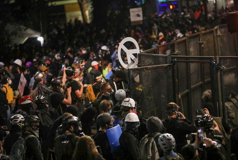 &copy; Reuters. Federal law enforcement officers deployed under the Trump administration&apos;s new executive order face off with protesters