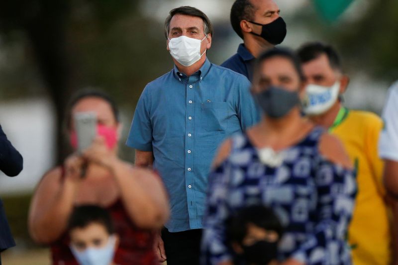 &copy; Reuters. El presidente de Brasil, Jair Bolsonaro, observa mientras se reúne con sus partidarios durante una ceremonia  en medio del brote de COVID-19 en el Palacio Alvorada en Brasilia, Brasil. 23 de julio de 2020.