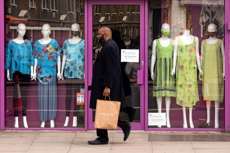 &copy; Reuters. Man walks past a closed retail outlet on a commercial road, in London