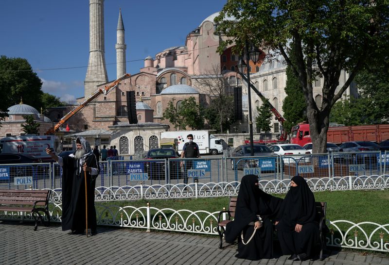 &copy; Reuters. A man takes a selfie as women chat in front of the Hagia Sophia Grand Mosque in Istanbul