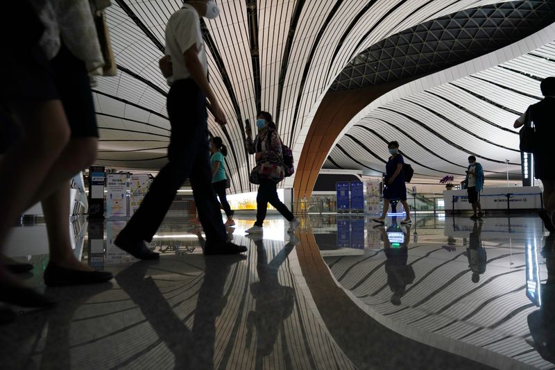 &copy; Reuters. People wearing face masks following the coronavirus disease (COVID-19) outbreak are seen at Beijing Daxing International Airport in Beijing