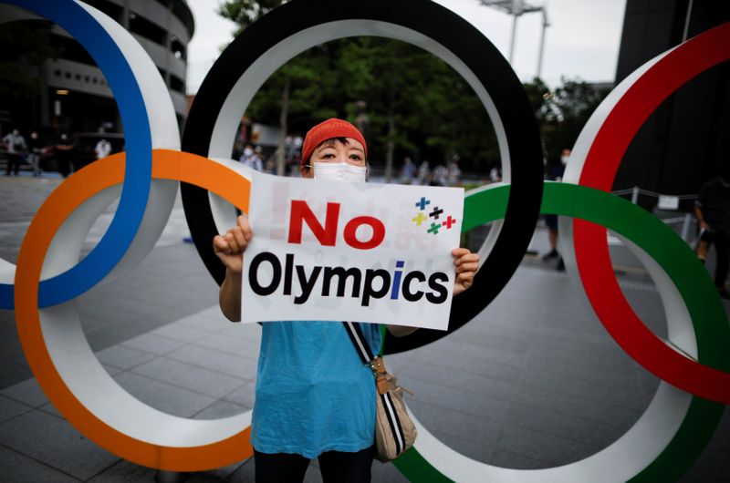 &copy; Reuters. Una manifestante con una mascarilla protesta contra la organización de los Juegos Olímpicos en Tokio el próximo año debido a la pandemia de coronavirus.  Japón, julio 24, 2020. REUTERS/Issei Kato