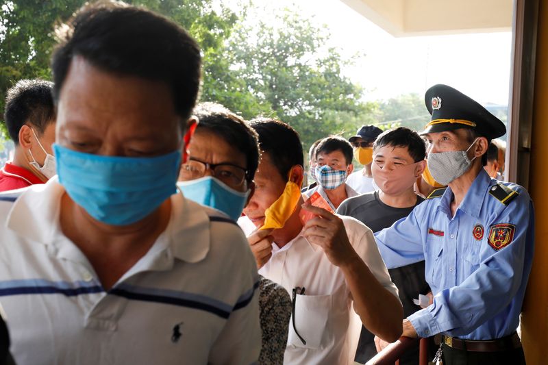 &copy; Reuters. Soccer fans wearing protective masks while they enter for a soccer match between Viettel and Duoc Nam Dinh of the Vleague after the Government eased nationwide lockdown following the coronavirus disease (COVID-19) outbreak in Nam Dinh