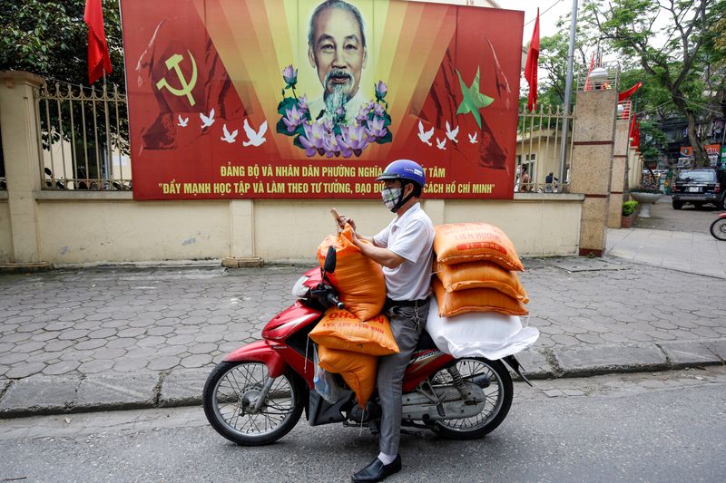 © Reuters. FILE PHOTO: A donor carries rice bags to contribute to poor people during coronavirus disease (COVID-19) outbreak in Hanoi