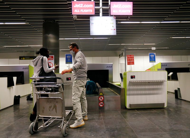 &copy; Reuters. FILE PHOTO: British tourists returning to UK, check in their luggage, as Britain imposed a two-week quarantine on all travellers arriving from Spain