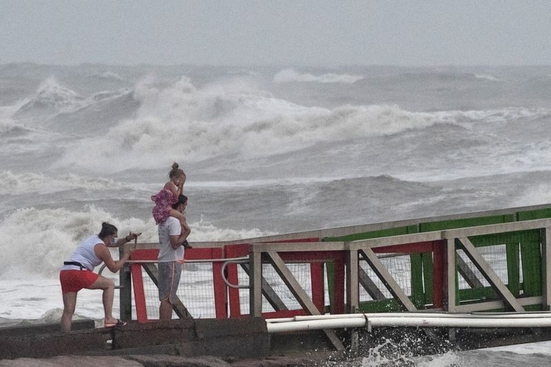 &copy; Reuters. A family watches high swells from Hurricane Hanna from a jetty in Galveston, Texas