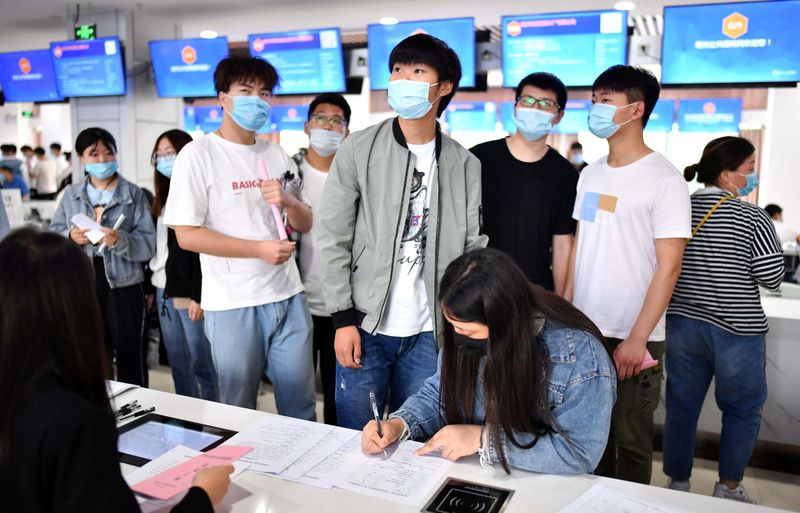 © Reuters. FILE PHOTO: People attend a job fair for college graduates in Bozhou