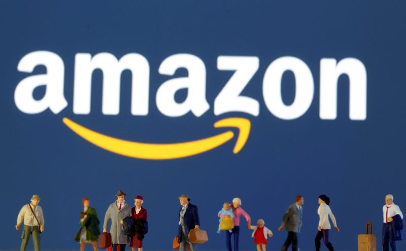 &copy; Reuters. Small toy figures are seen in front of diplayed Amazon logo