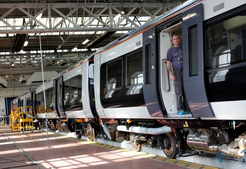 © Reuters. FILE PHOTO: A worker stands in the doorway of a train at the Bombardier plant in Derby