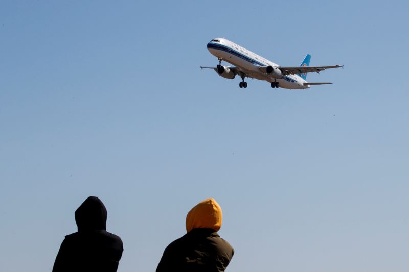&copy; Reuters. FILE PHOTO: People watch a plane of China Southern Airlines land at Beijing Capital International in Beijing as the country is hit by an outbreak of the novel coronavirus