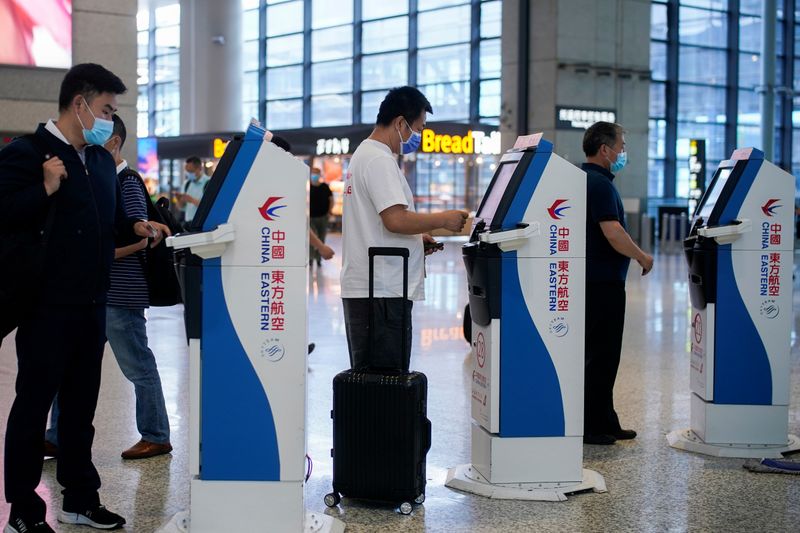 &copy; Reuters. FILE PHOTO: People wearing face masks are seen at Hongqiao International Airport in Shanghai