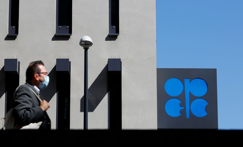© Reuters. FILE PHOTO: A person passes the OPEC logo in front of its headquarters in Vienna