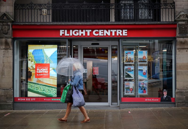 &copy; Reuters. A woman walks past a Flight Centre travel agency in Chester