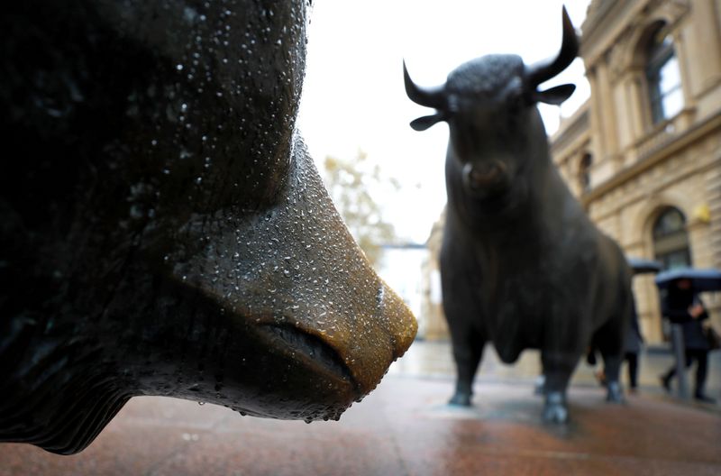 &copy; Reuters. FILE PHOTO: People with umbrellas pass by bull and bear outside Frankfurt&apos;s stock exchange during heavy rain in Frankfurt
