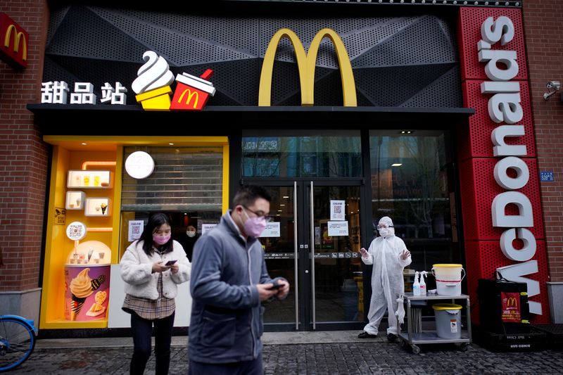 &copy; Reuters. FILE PHOTO: People wearing face masks are seen outside a McDonald&apos;s restaurant in Wuhan