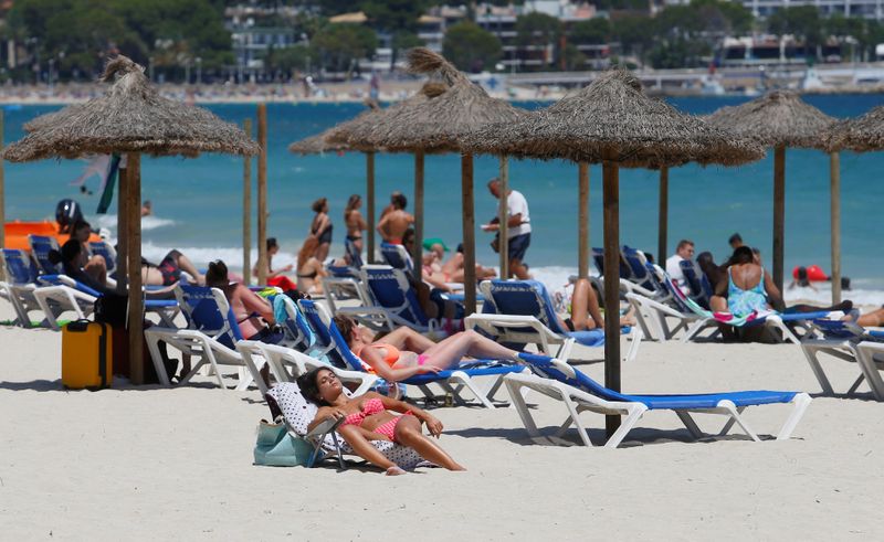 &copy; Reuters. FILE PHOTO: People sunbathe in Magaluf beach