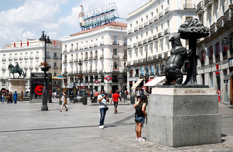 &copy; Reuters. Mulher posa para foto ao lado de estátua na praça Puerta del Sol, em Madri