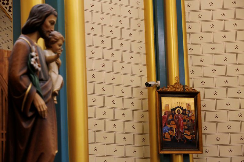 &copy; Reuters. FILE PHOTO: Surveillance camera is seen near a religious painting during a mass at Xishiku Cathedral on Christmas Eve in Beijing