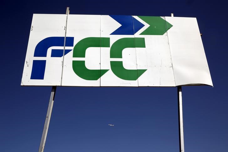 © Reuters. Un avión pasa junto a un cartel de FCC en Tres Cantos, Madrid