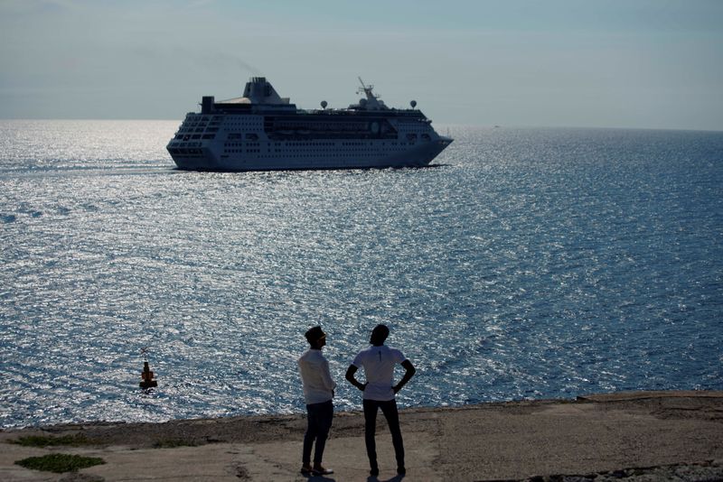 &copy; Reuters. FILE PHOTO: Men watch the cruise ship MS Empress of the Seas, operated by Royal Caribbean International, as it leaves the bay of Havana