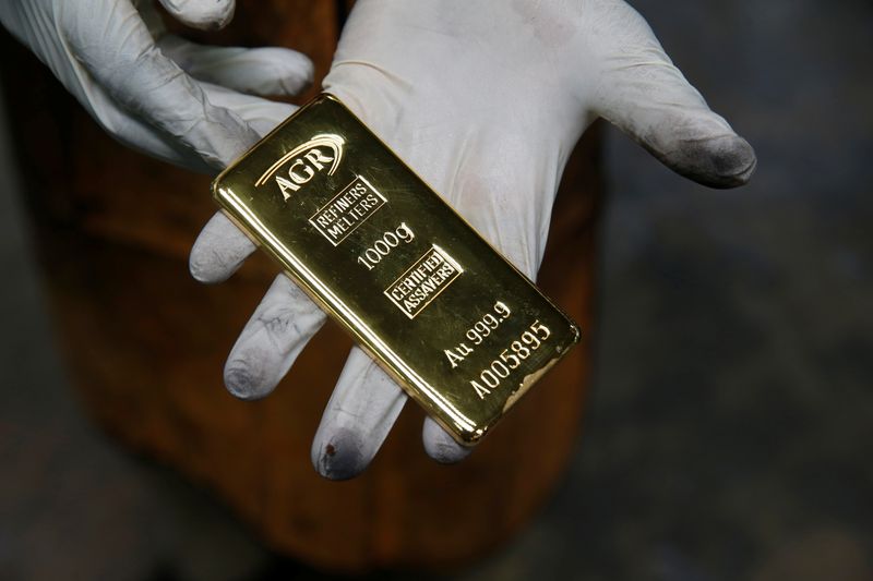 &copy; Reuters. Работник завода AGR взвешивает слиток золота весом 1 кг в Энтеббе