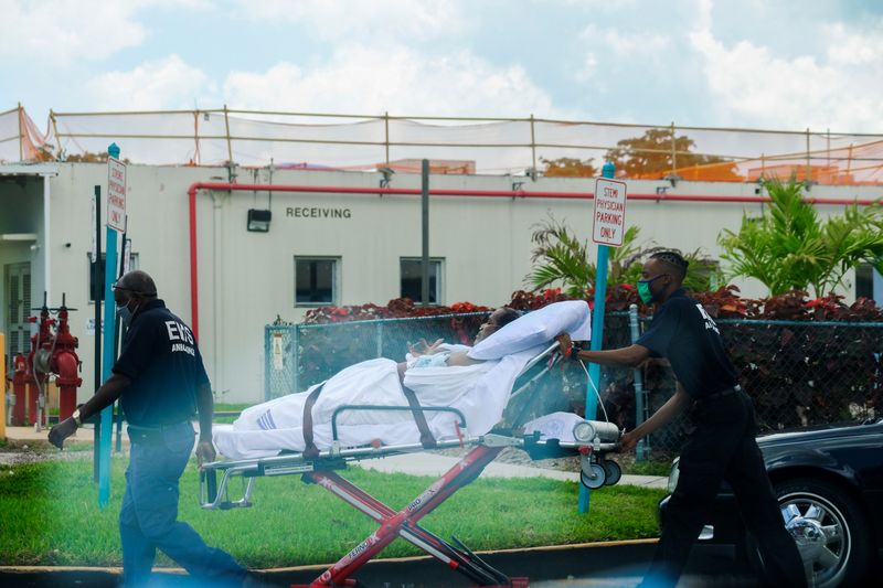 &copy; Reuters. Emergency Medical Technicians (EMT) leave with a patient at North Shore Medical Center where the coronavirus disease (COVID-19) patients are treated, in Miami