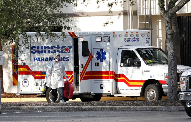 &copy; Reuters. A paramedic dressed in personal protective equipment exits an ambulance at St. Petersburg General Hospital in Florida