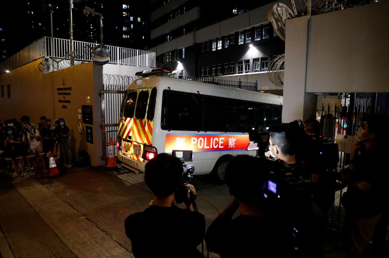 &copy; Reuters. Reporters take pictures and video of a police vehicle driving inside a station where believed members of Hong Kong pro-independence group arrested by the national security unit are held in Hong Kong