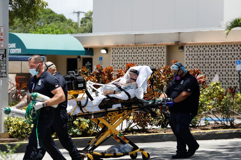 © Reuters. Emergency Medical Technicians (EMT) leave with a patient at Hialeah Hospital where the coronavirus disease (COVID-19) patients are treated