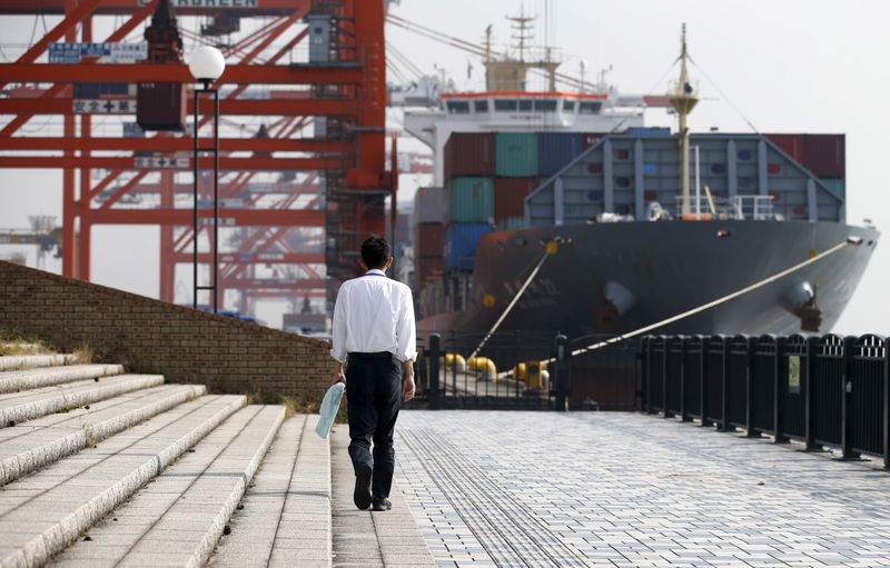 &copy; Reuters. A man walks near a container ship at a port in Tokyo