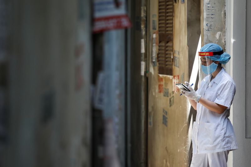 &copy; Reuters. A healthcare worker is seen at a lane near the house of a coronavirus disease (COVID-19) patient while investigating infection links in Hanoi